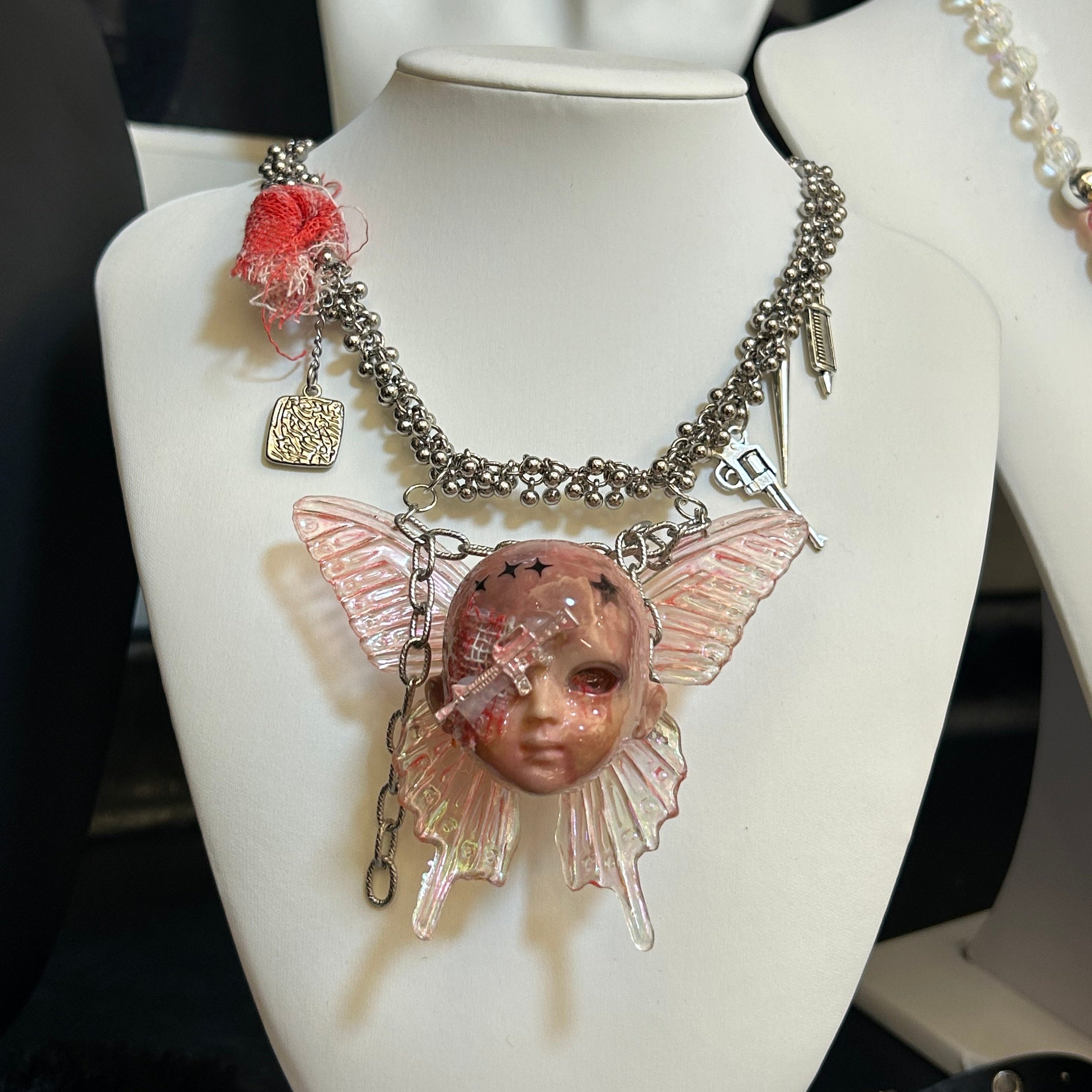 Battle-damaged version bandage doll head necklace