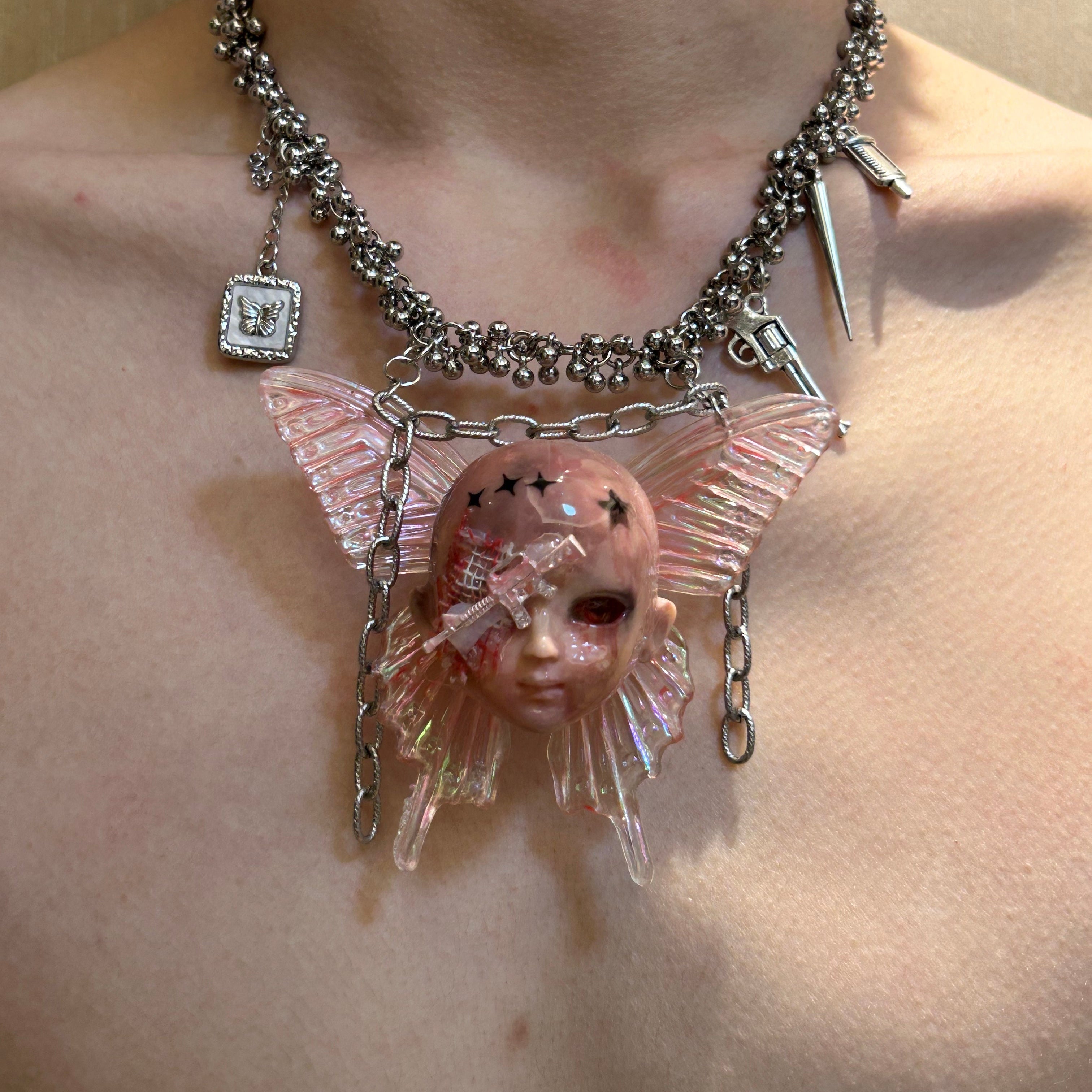 Battle-damaged version bandage doll head necklace